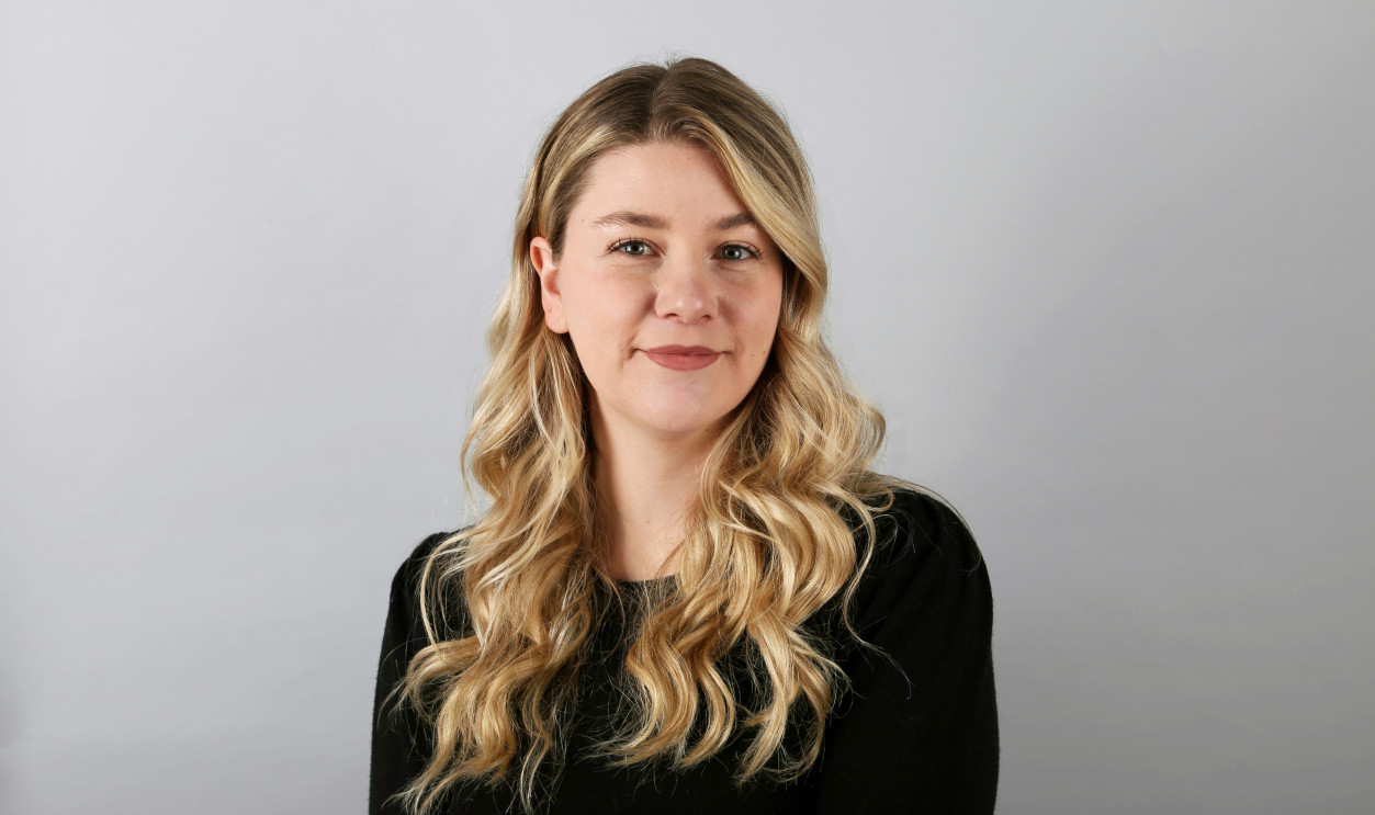 a woman with long blonde hair wearing a black shirt