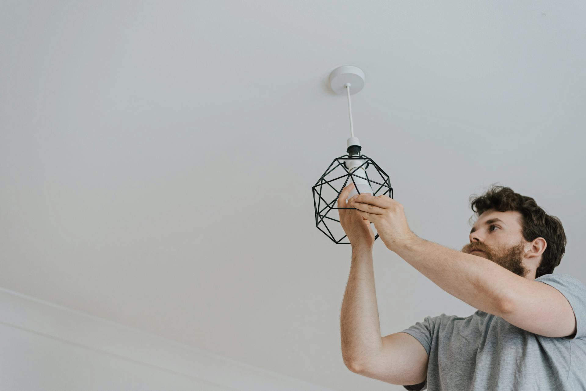 Man screwing light bulb into lamp