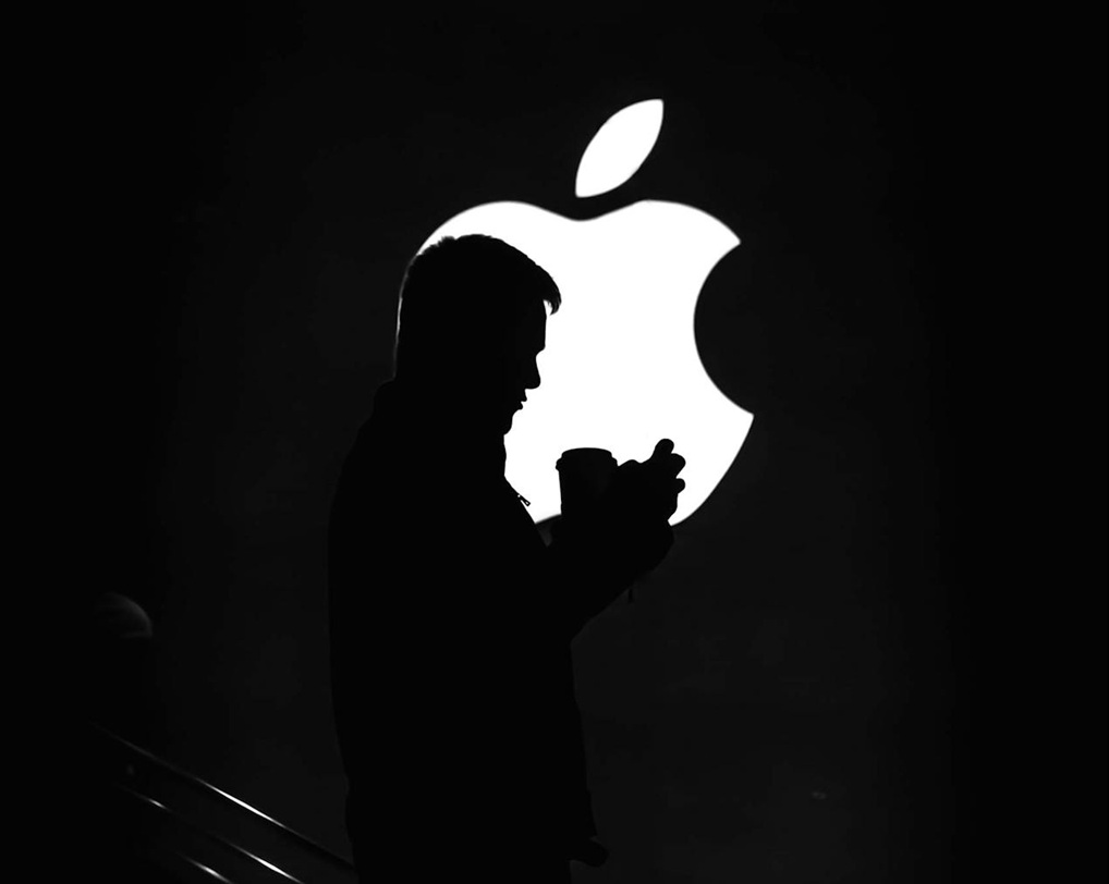 Silhouette of Man on Stairs in front of Apple logo.