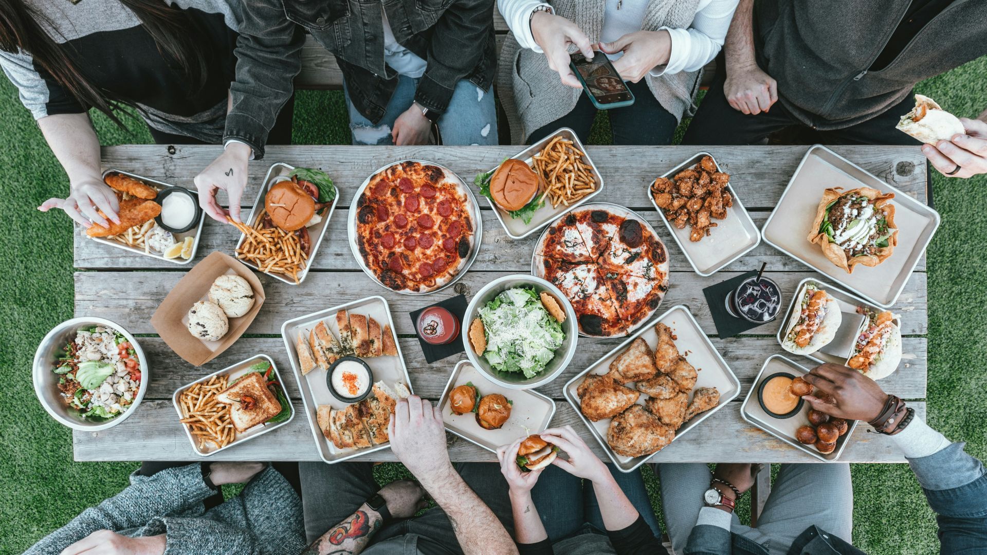 a group of people sitting around a table with food