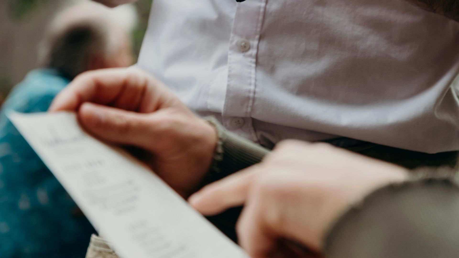 man in white button up shirt holding black and white box