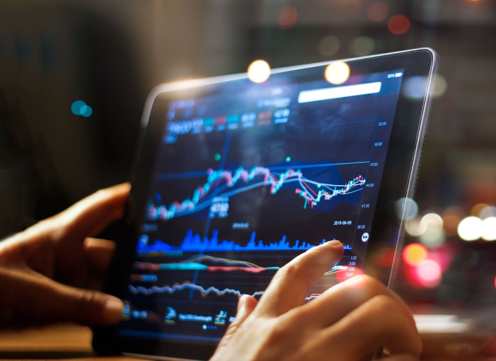 Businessman checking stock market data on tablet at night