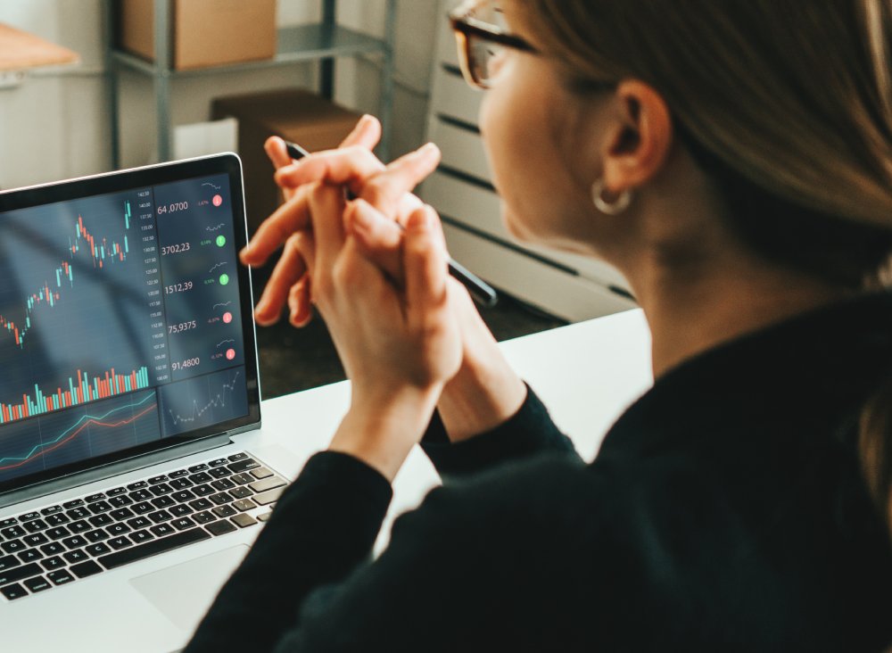 Woman working alone with stock market using laptop
