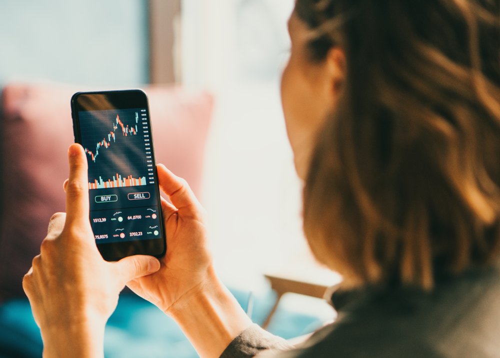 Woman using mobile phone investing application