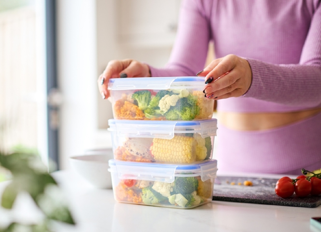 Woman At Home In Kitchen Making Healthy Meals For The Freezer