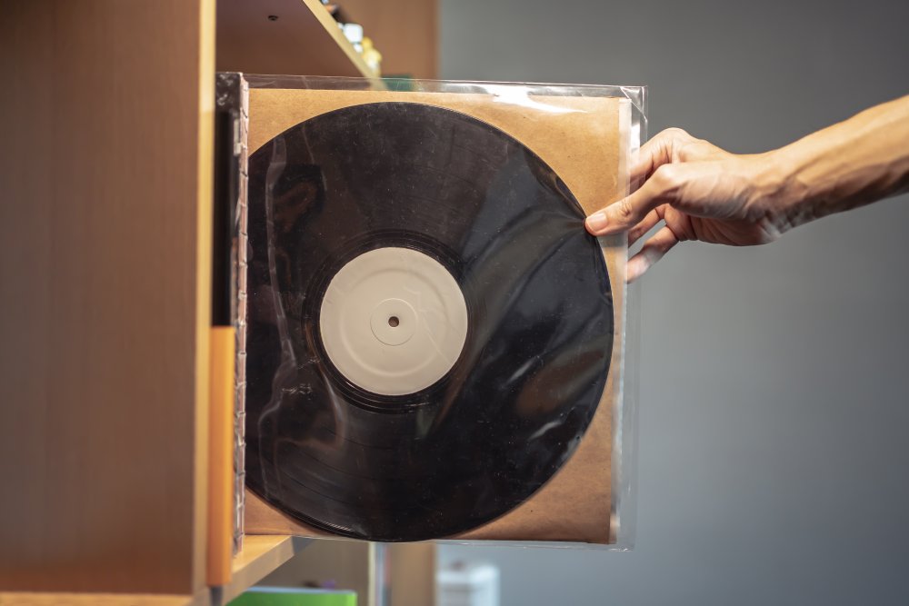 Persons Hand Picking a vinyl record from a shelf