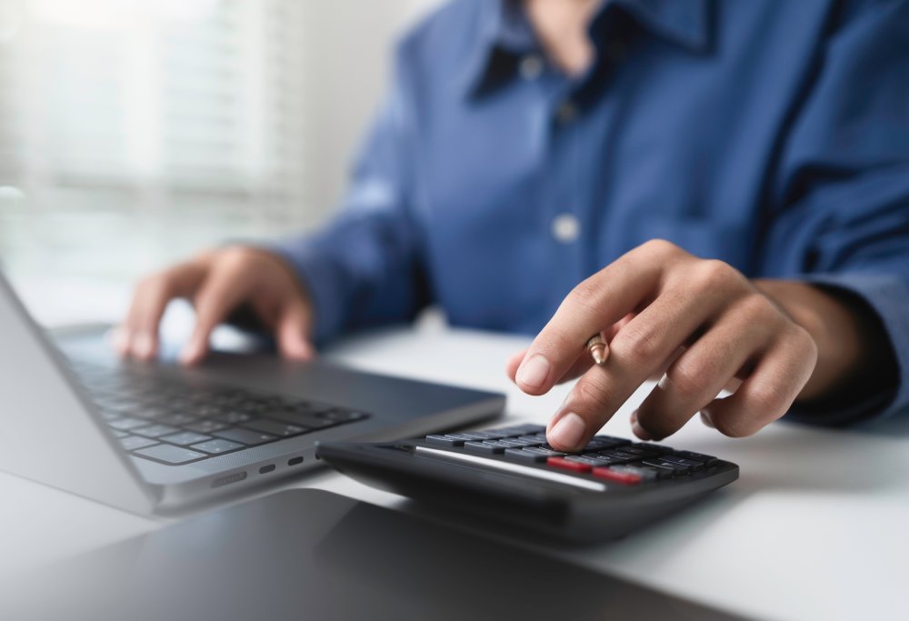 Close up businessman hand using calculator to budgeting and tax calculation
