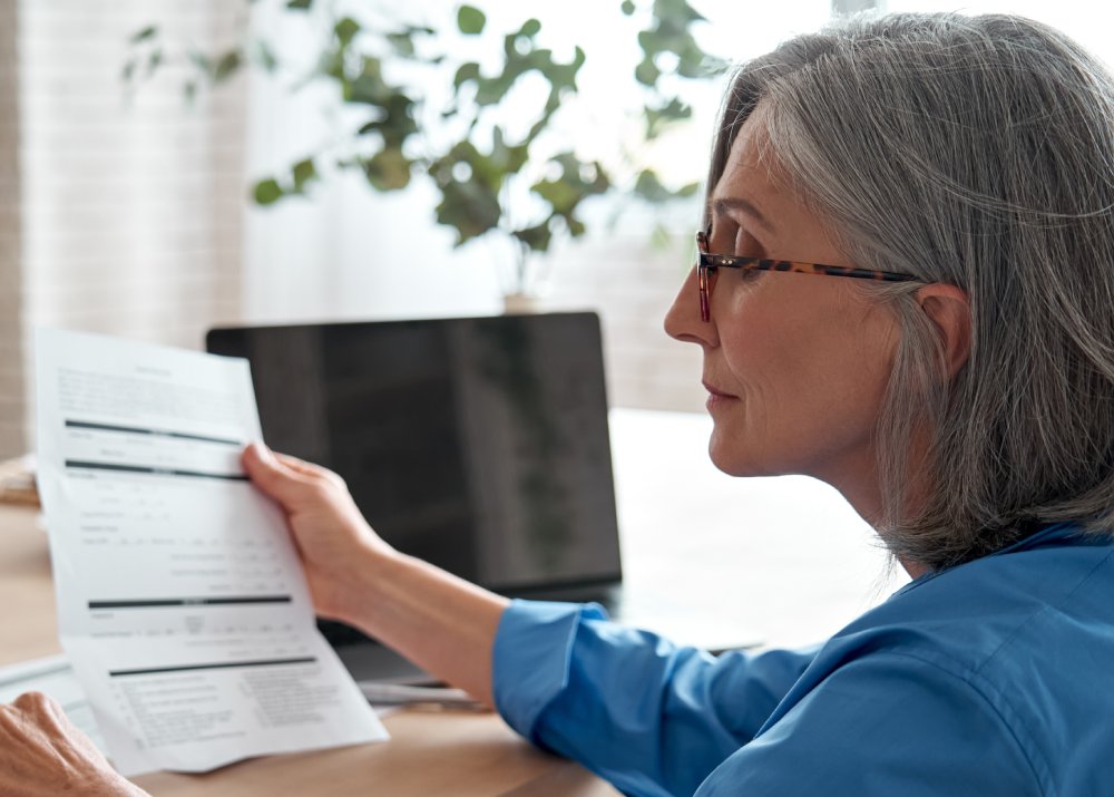 Portrait Photo of Business woman holding paper bill using calculator