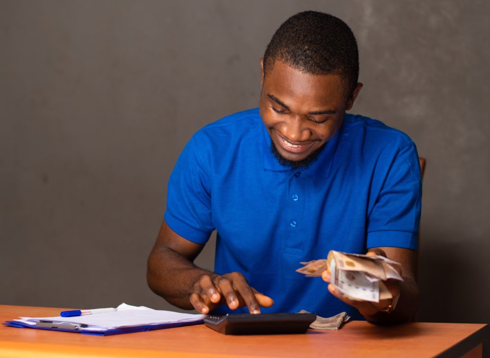 Portrait Photo young man using a calculator and counting money