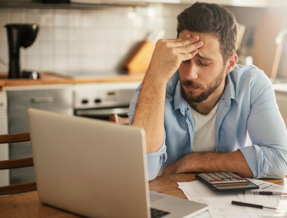Worried young man going over his bills and home finances