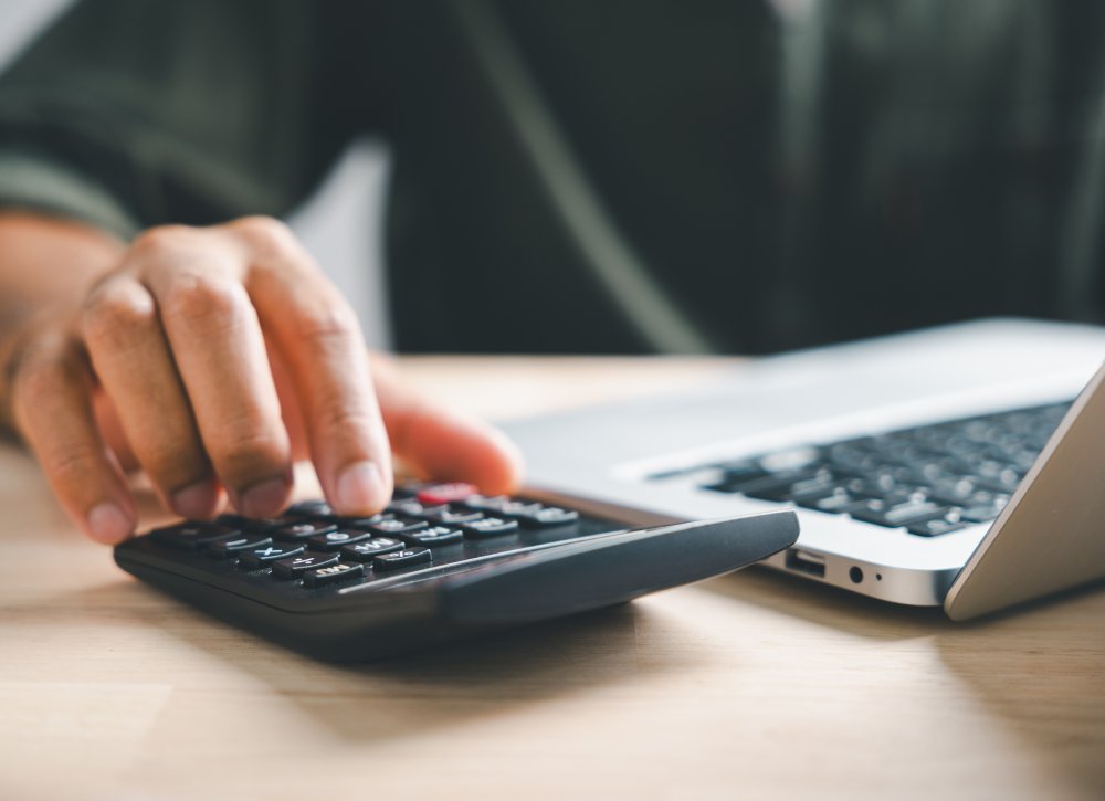 Close Up Photo of Hand on calculators, aiming for home refinance