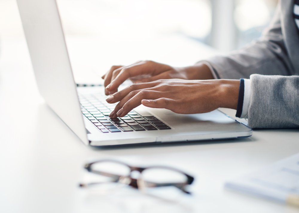 Hands of woman at laptop for research, business review or online report
