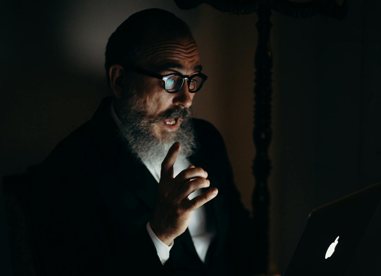 Man Working on Laptop in Dim Light