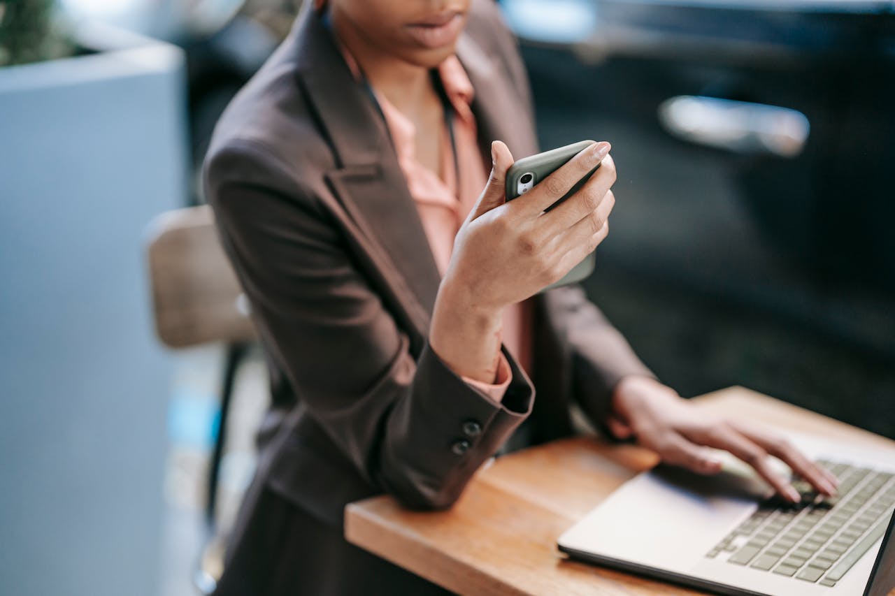 Woman surfing on laptop and using smartphone.