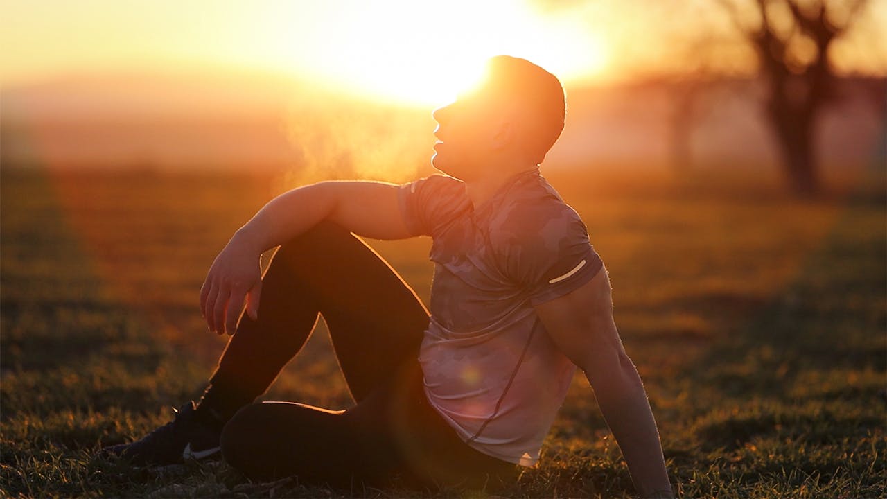 Man Sitting and Breathing at Sunset