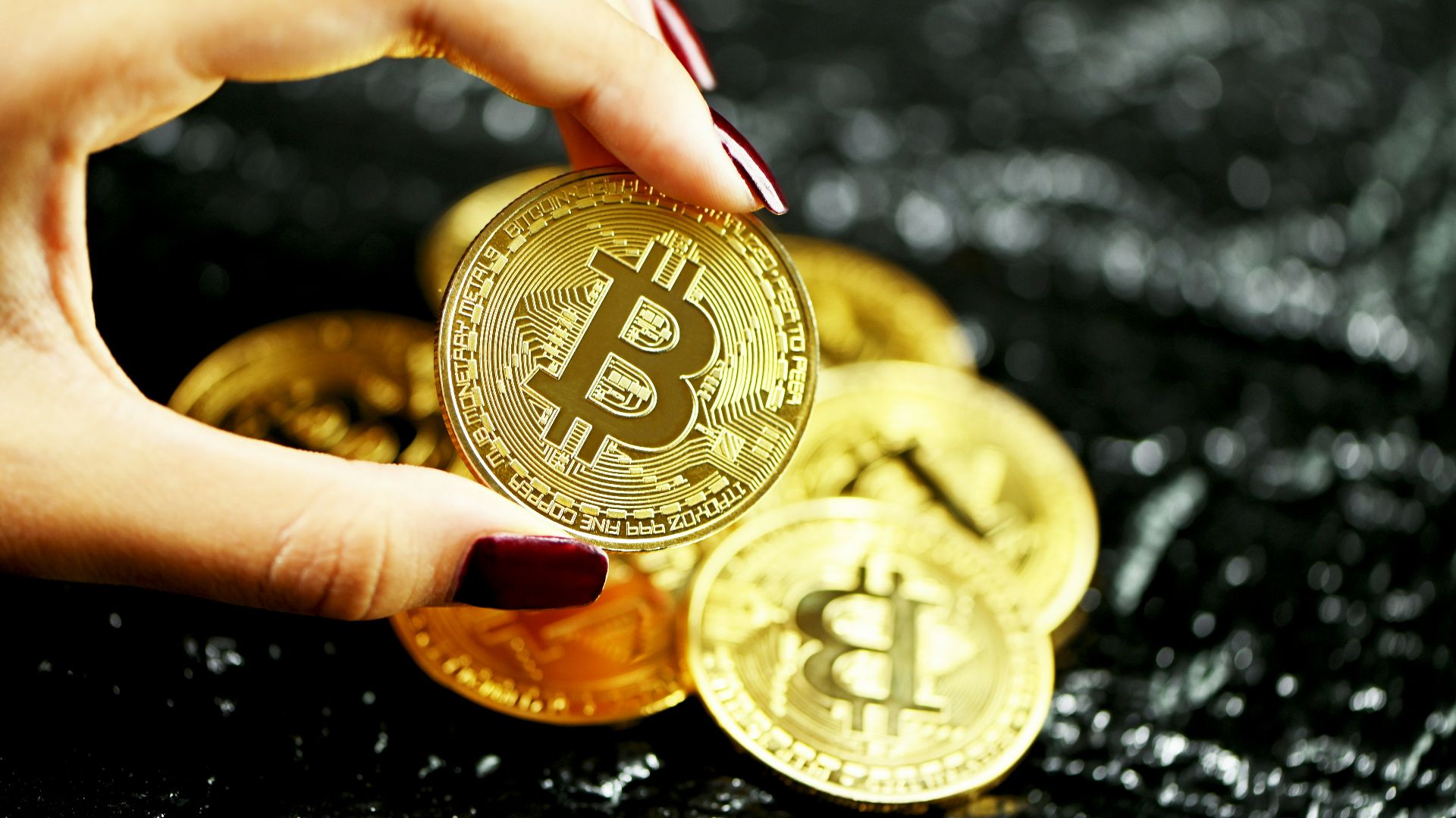 gold round coin on persons hand