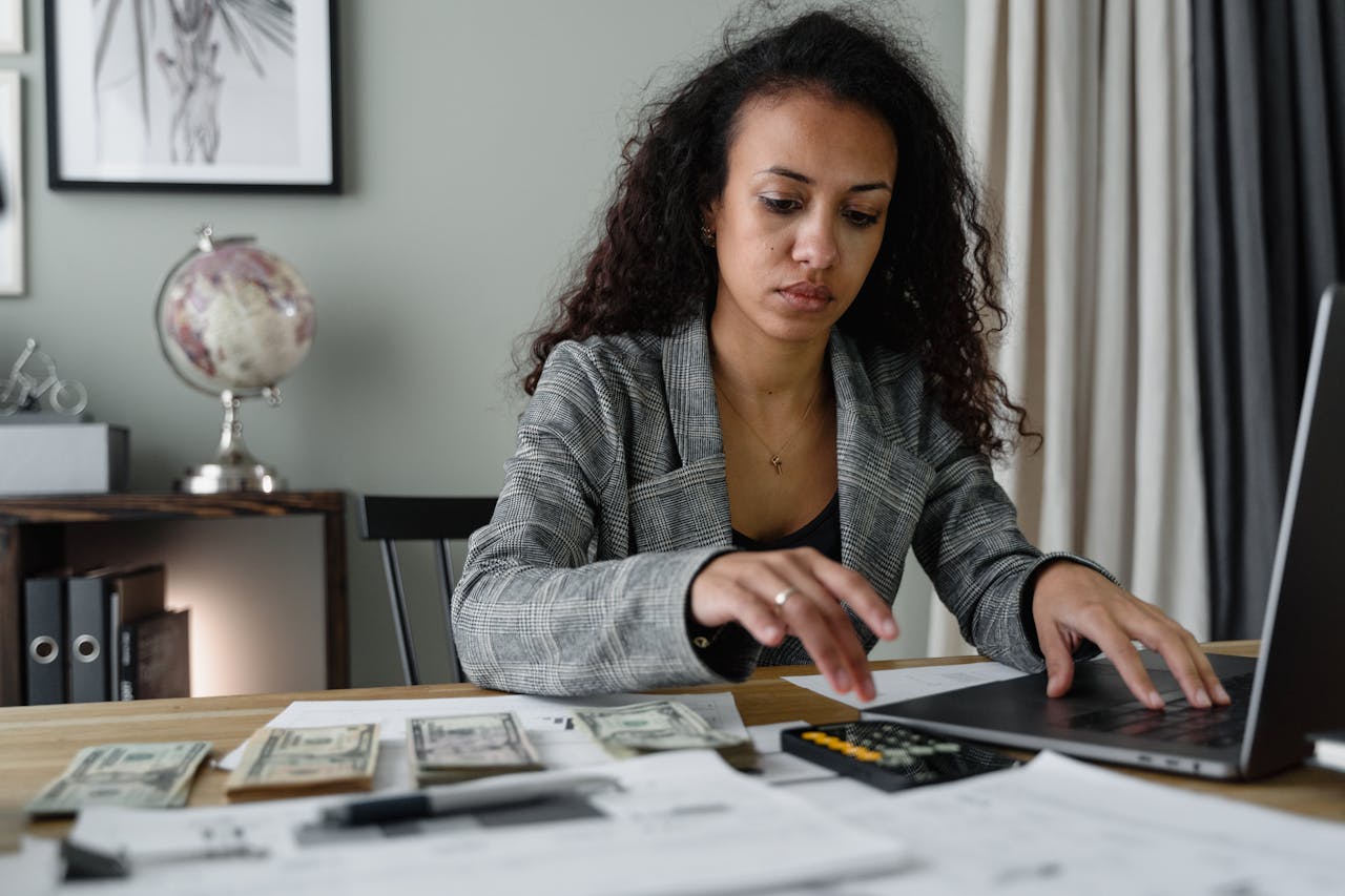 A Woman in Plaid Blazer Using Her Laptop