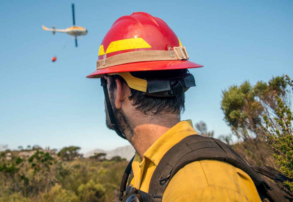 Portrait Photo of Wildland firefighter watching turning helicopter at wildfire