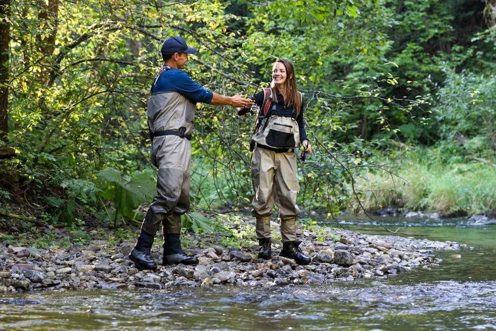 Portrait Photo of young woman learning to fly fishing with a guide