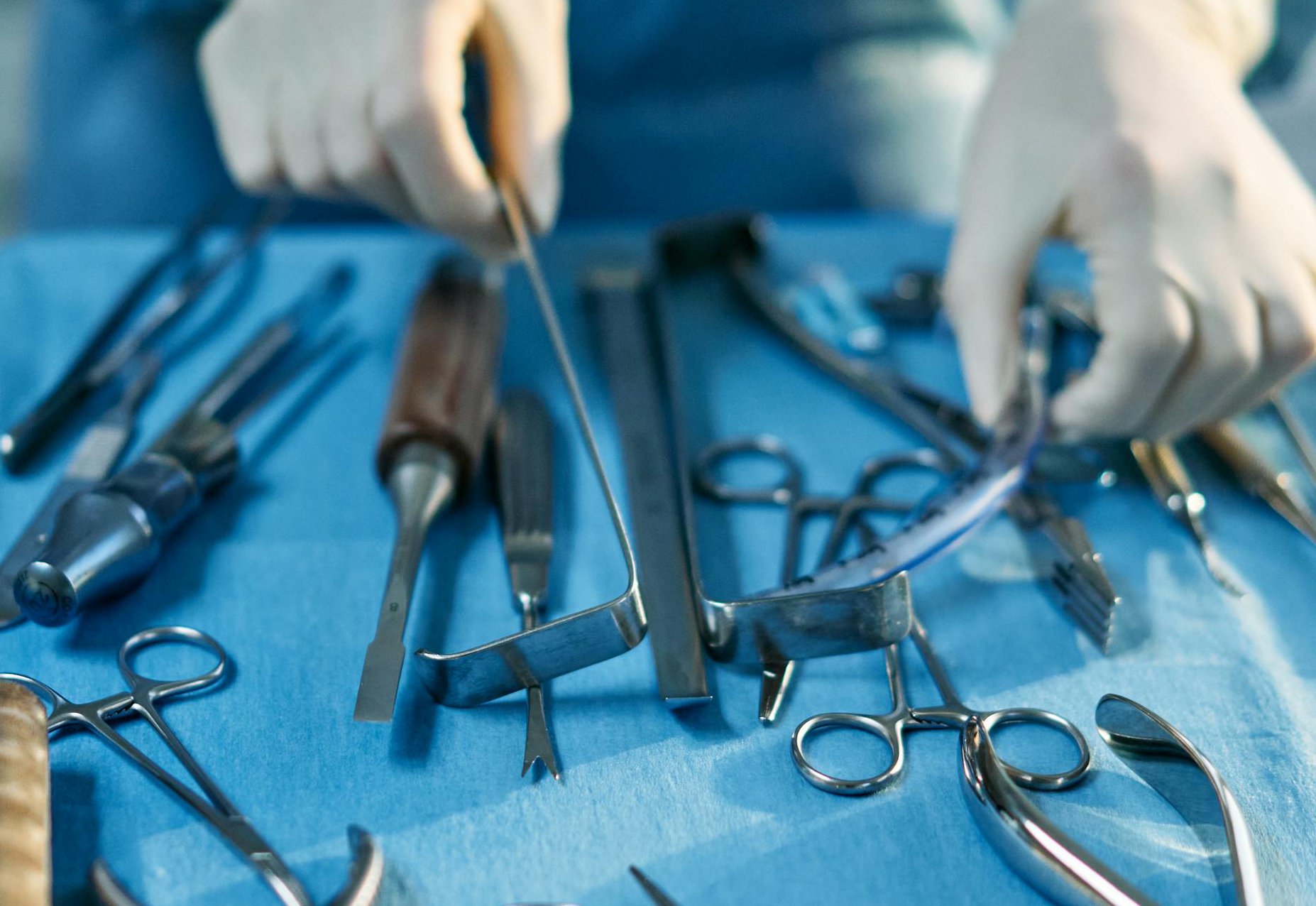 Person Holding Silver Medical Tools