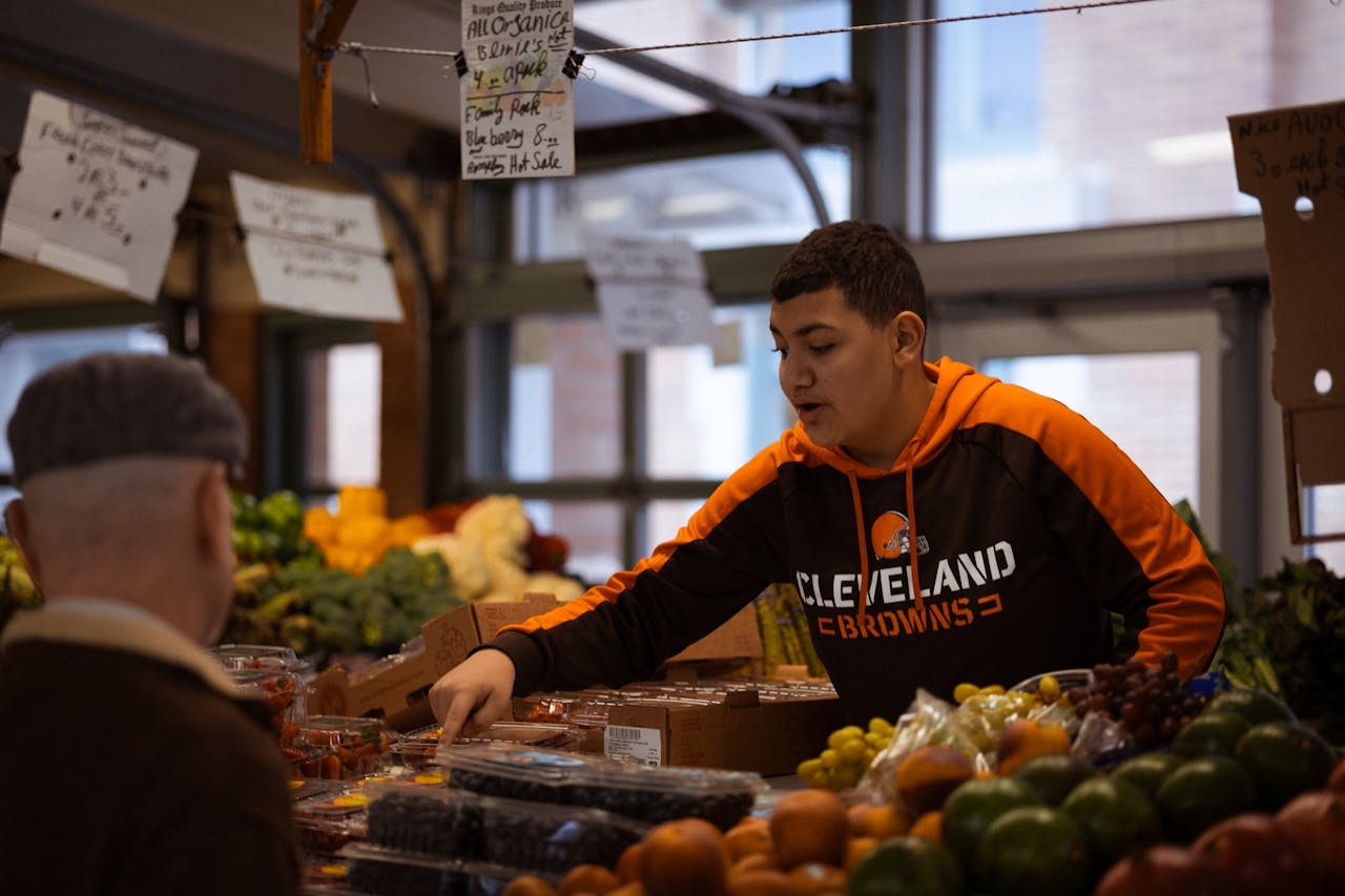 Young Man Selling Produce at Indoor Market