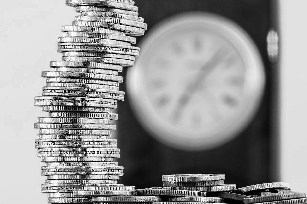 The image is a black and white photograph focusing on stacks of coins