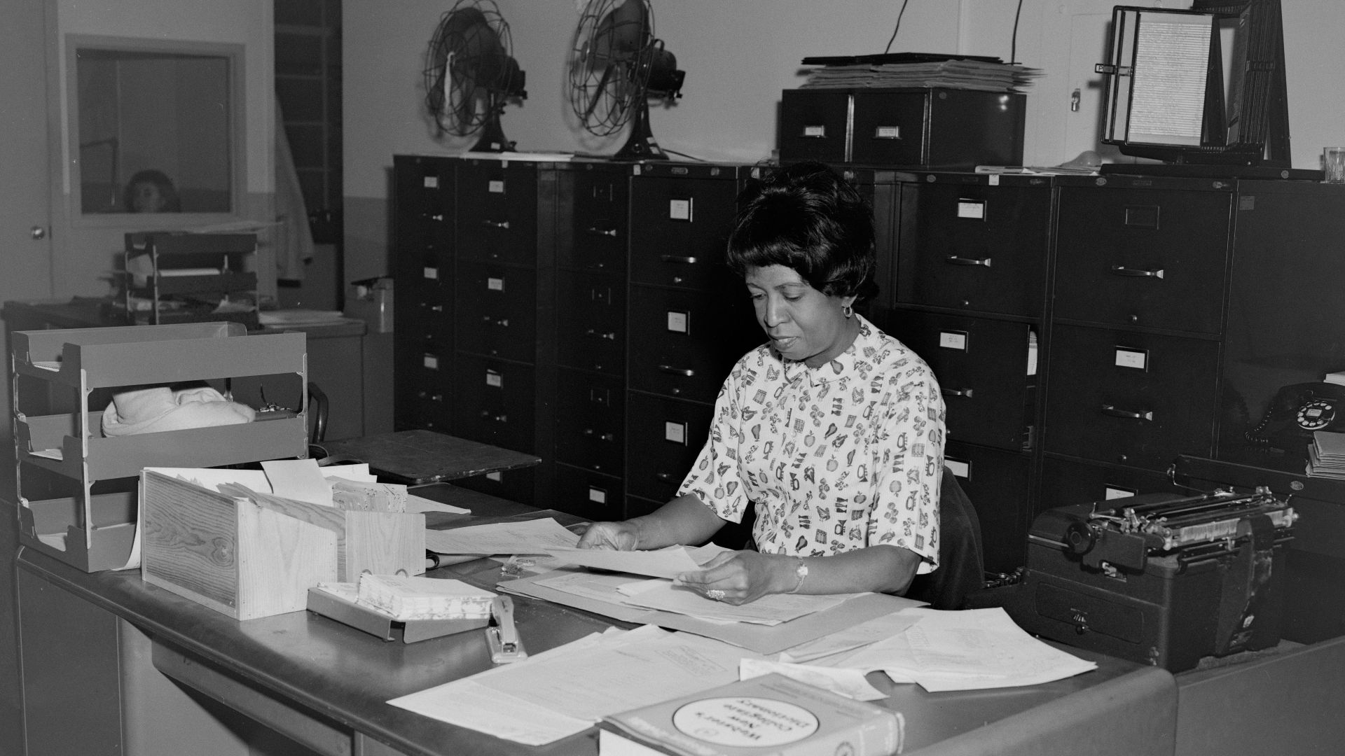 woman in white and black polka dot shirt sitting on chair