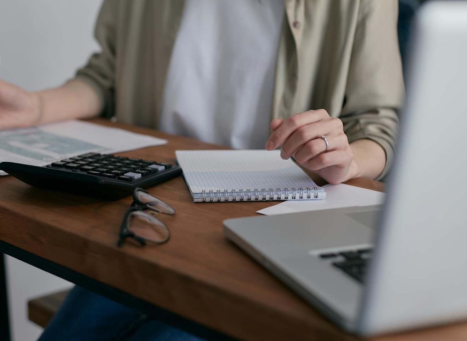 The image shows a close-up of a person's hands working at a desk
