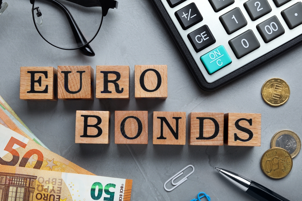 Flat lay composition with banknotes and word Eurobonds made of wooden cubes on grey table