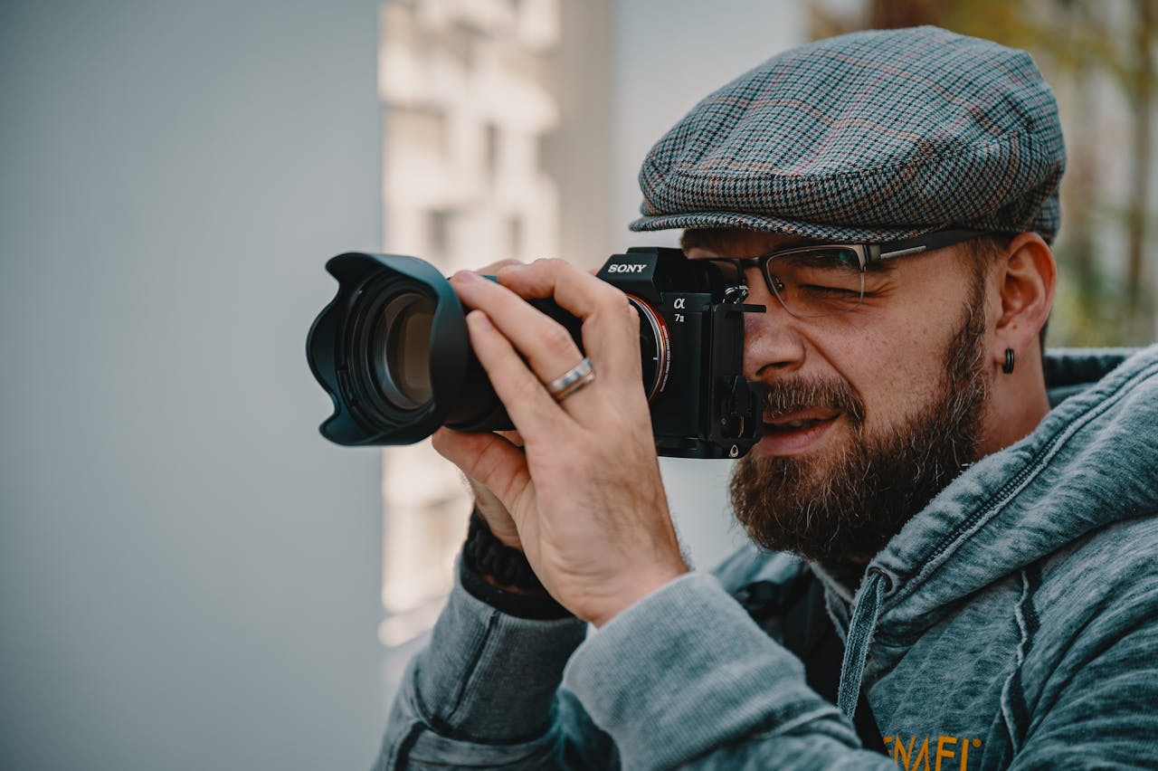 Man in Blue Denim Jacket Holding Black Dslr Camera