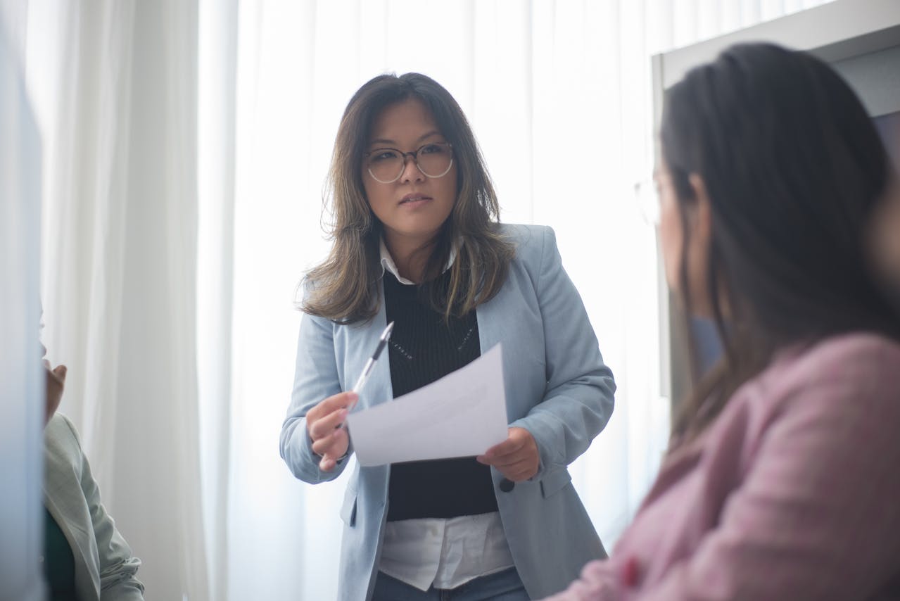 Woman in Blue Blazer Holding a Paper and Pen