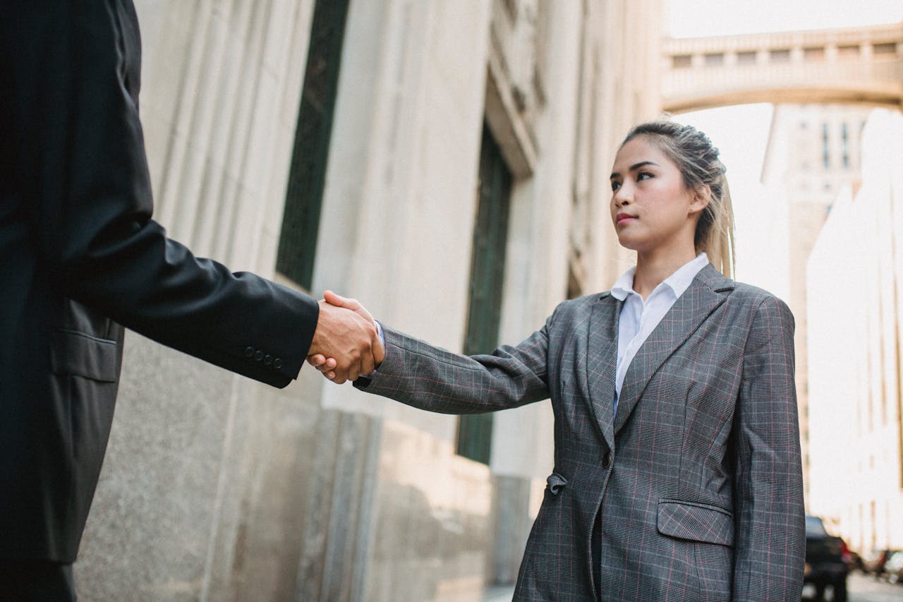 Young Business Woman Shake Hands with Unrecognizable Man