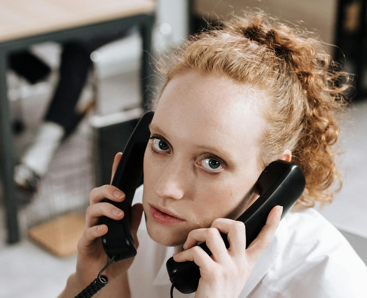 Young Woman in White Sleeveless Blouse Talking on the Phone