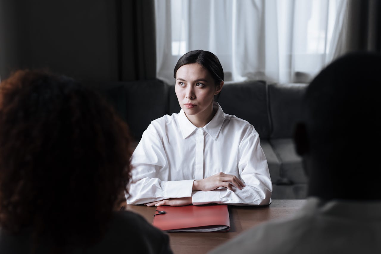 Social Worker Sitting at Table with Documents Folder in Front of Her