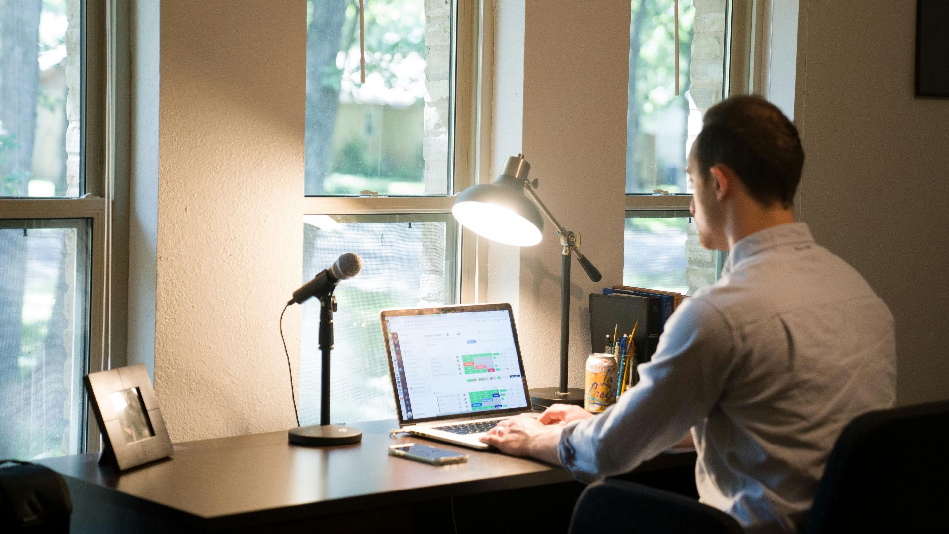 man in white dress shirt sitting on chair using laptop computer