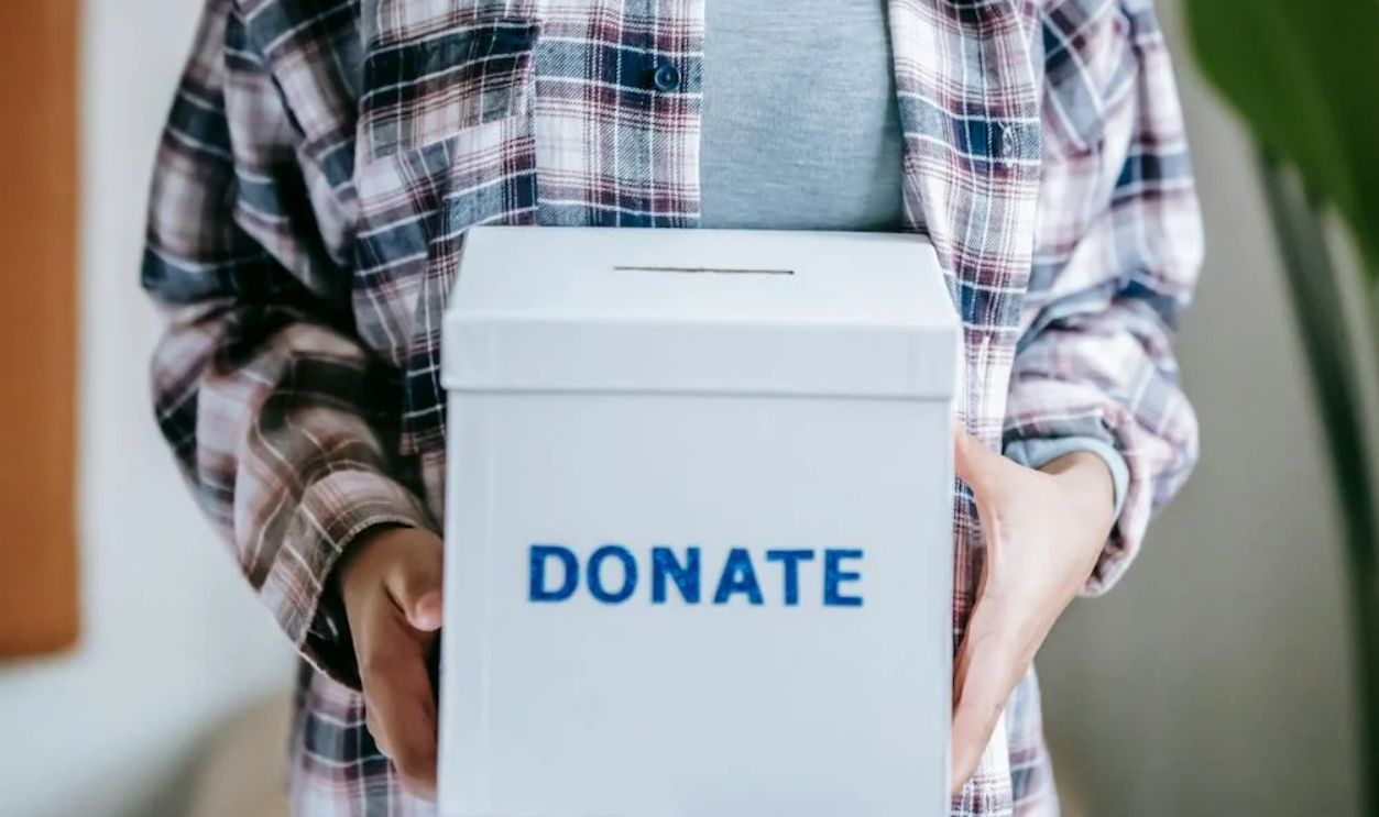 Cheerful ethnic woman with donate box