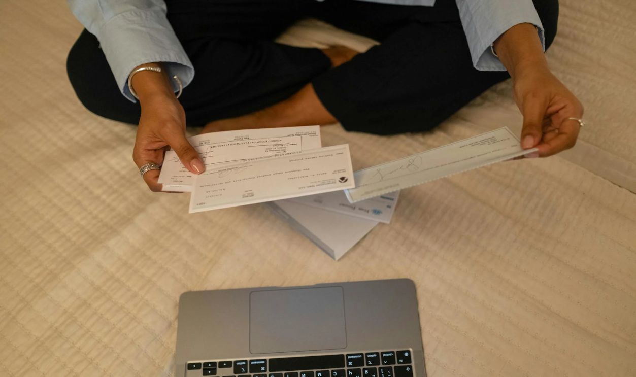 Photo of a Person's Hands Holding Cheques