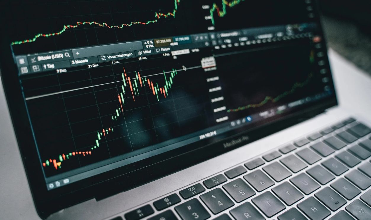 Black and Silver Laptop with Stock Market Display on Screen