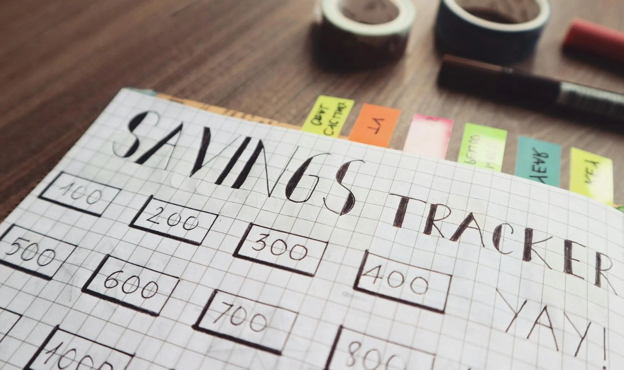 Savings Tracker on Brown Wooden Surface
