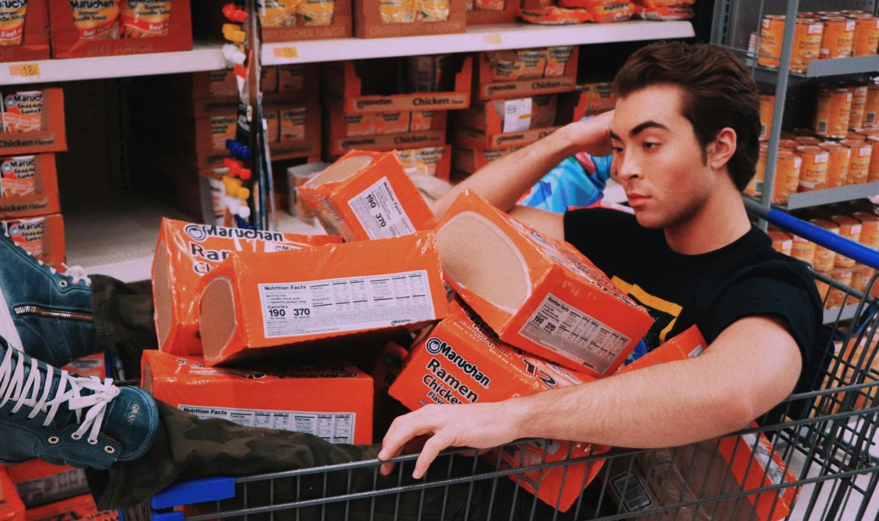 Man Sitting on Shopping Cart