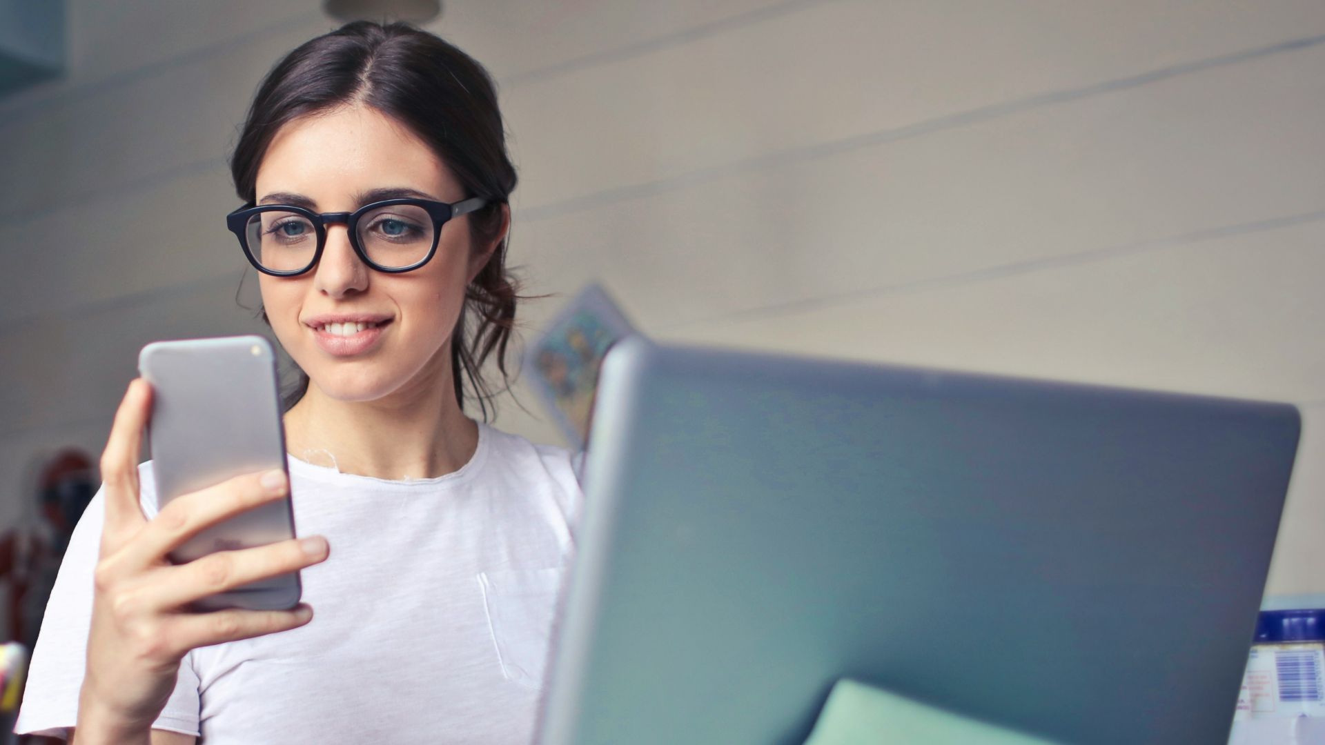 woman in white shirt using smartphone