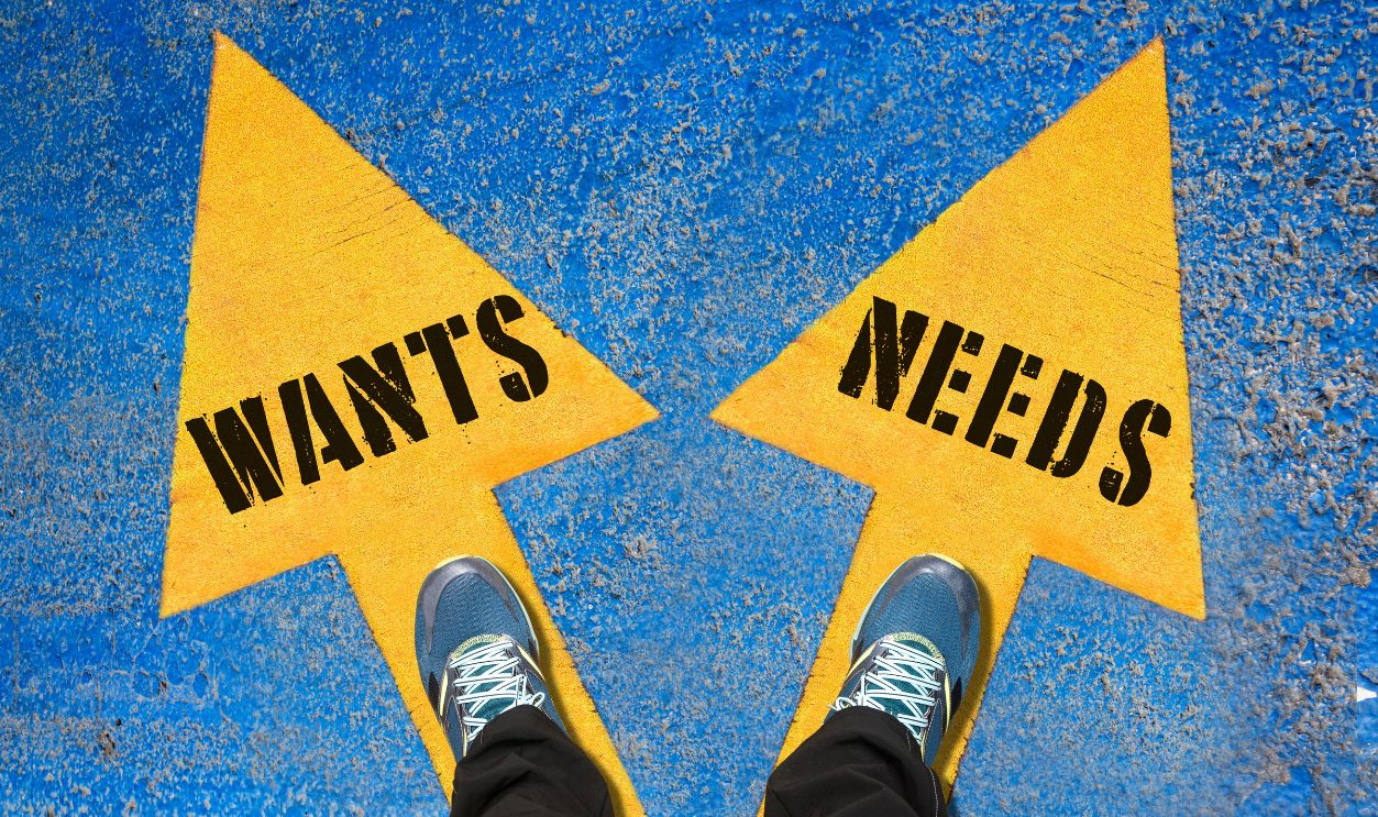 WANTS and NEEDS , Choice Concept , Two Yellow Arrows Painted on Asphalt showing different directions