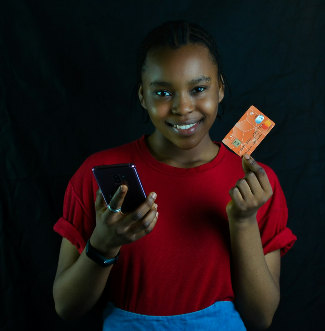 a woman holding a cell phone and a credit card