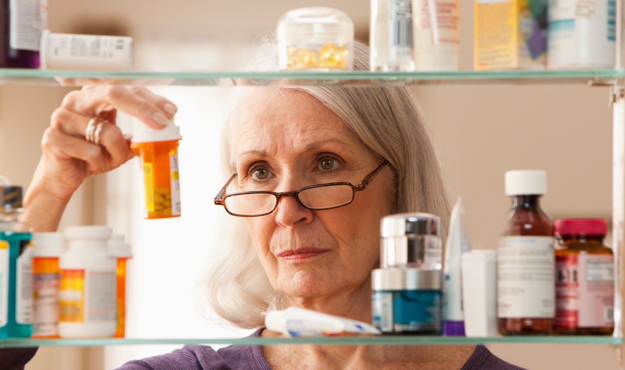 Senior woman looking at prescription bottles 