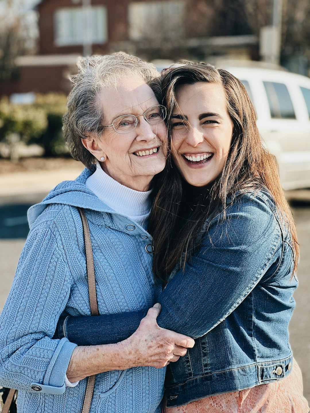 two women hugging each other in a parking lot