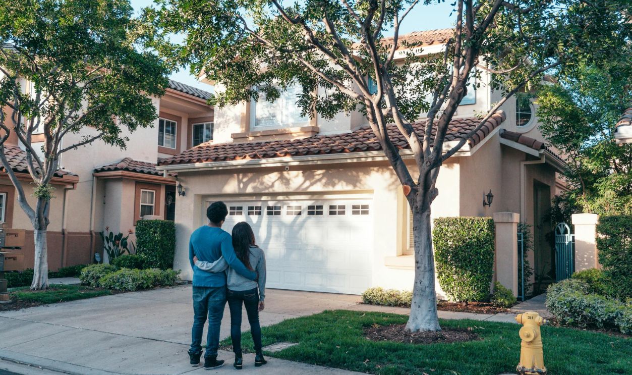 Couple Standing In Front of their House