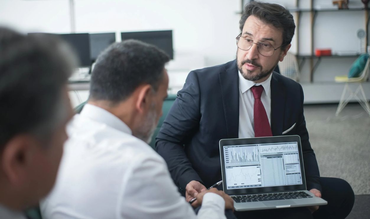 Man in Black Suit Talking to His Colleagues