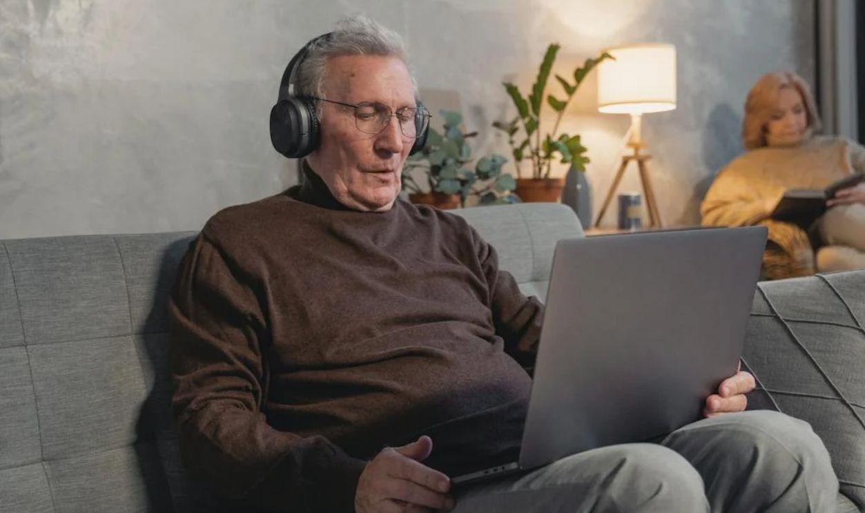 Man Using Laptop and Wearing Headset