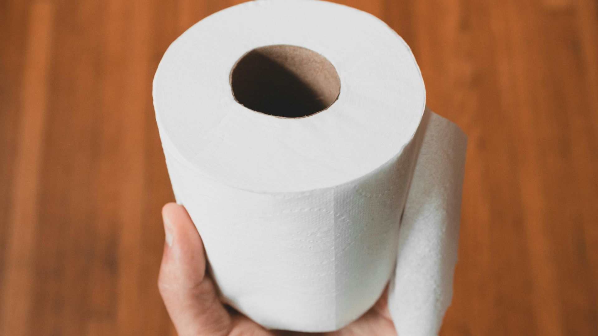 person holding white toilet paper roll