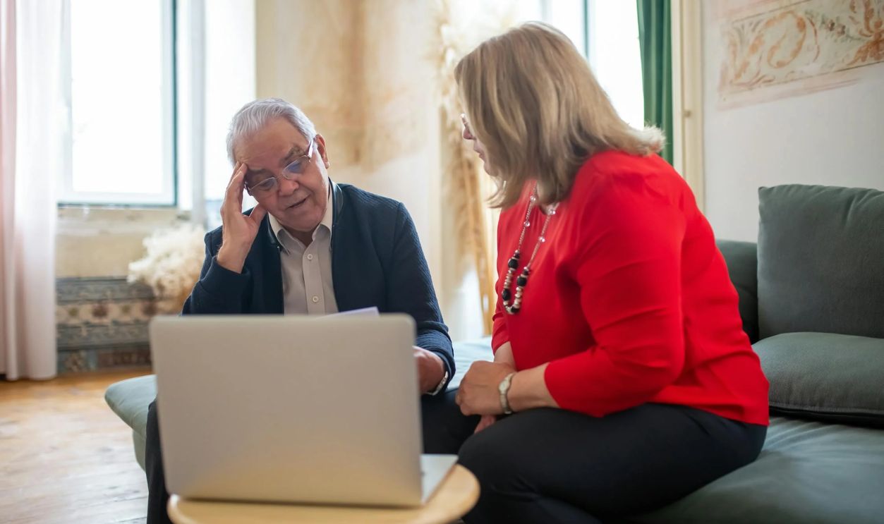 Mature Couple Looking at a Laptop Monitor and Talking